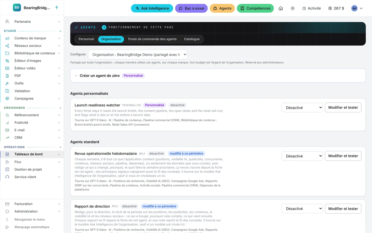 L’onglet Organisation du module Agents : en tête, un agent de veille personnalisé de préparation des lancements qui lit des données de l’application, un dossier de la bibliothèque et un système connecté ; en dessous, les agents standard, chacun avec son modèle, ses sources, son réglage Activé ou Désactivé et un bouton Modifier et tester