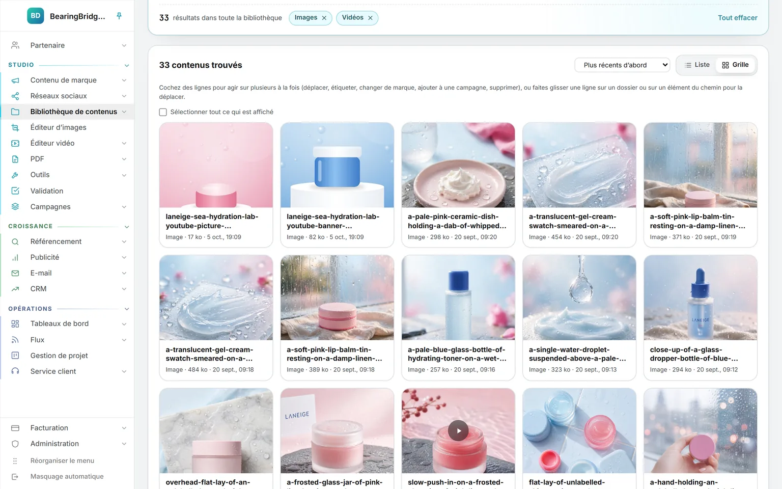 Toute la bibliothèque filtrée sur les images et les vidéos (31 éléments), en grille : des photos de produits générées et un clip, chaque carte portant son nom, sa taille et sa date