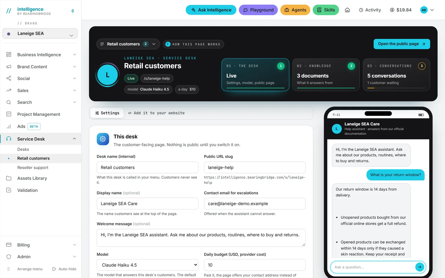 A desk’s settings: public address, display name, contact email, welcome message, model and daily budget, with the live switch, and beside them a phone that has just answered a test question about the return window