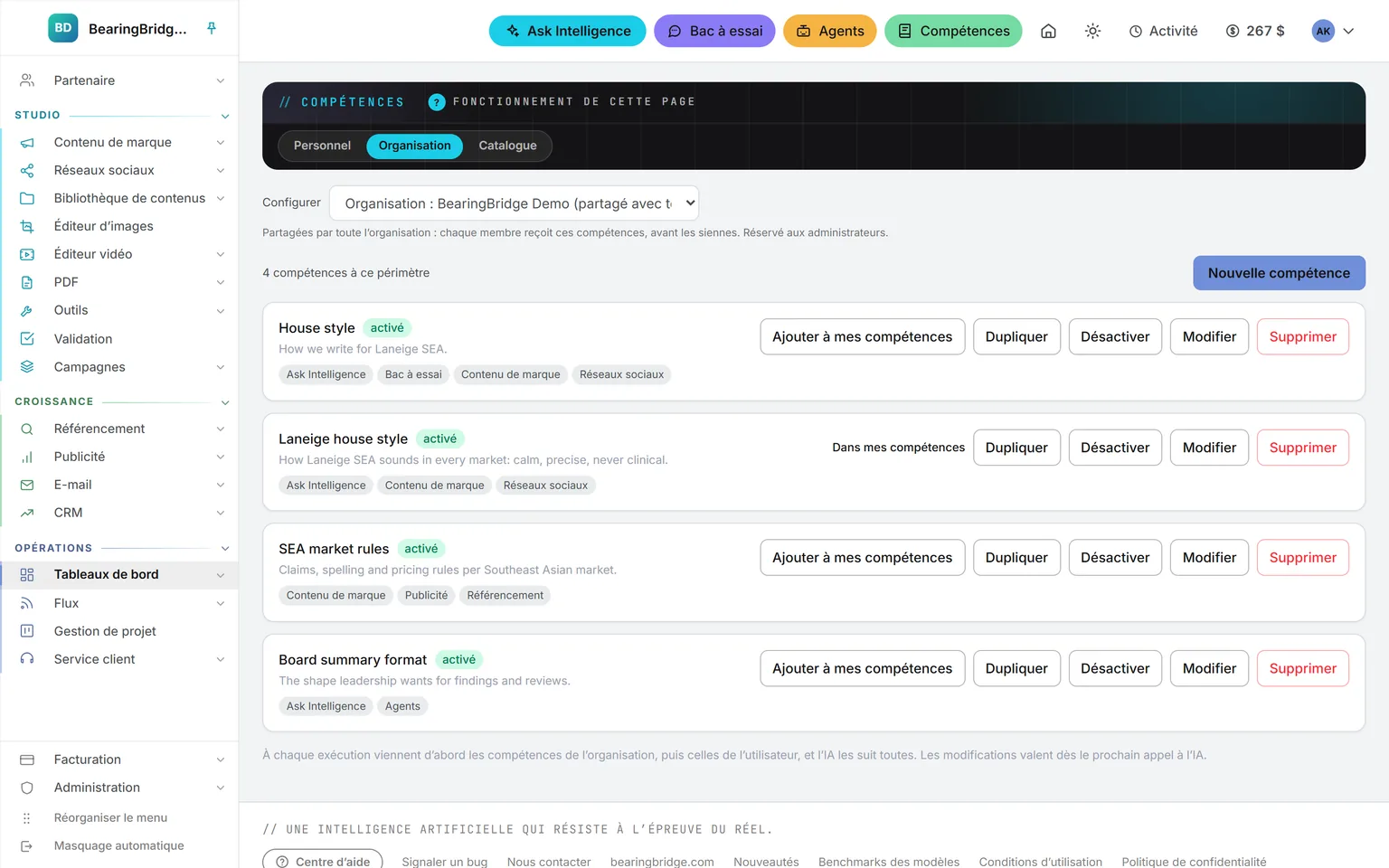 L’onglet Organisation de la page Compétences : les quatre compétences de l’organisation de démonstration (House style, Laneige house style, SEA market rules et Board summary format), chacune avec son champ d’application, Ajouter à mes compétences (ou Dans mes compétences une fois ajoutée) et des boutons pour la dupliquer, la désactiver, la modifier ou la supprimer